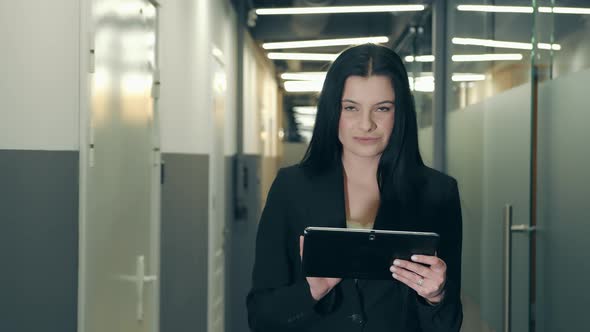 Portrait of a Successful Businesswoman in Glasses and Black Clothes of European Appearance Standing