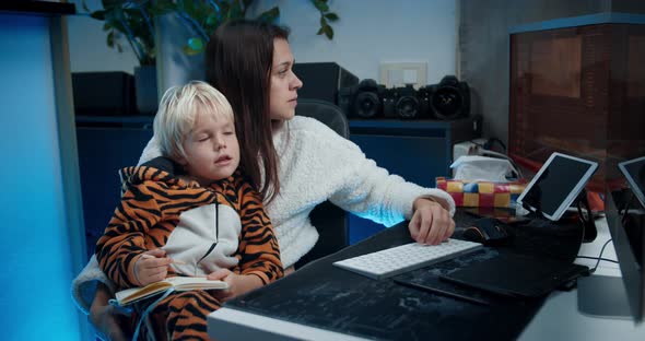 Attractive Freelance Woman Working in Front of Computer at Home with Child