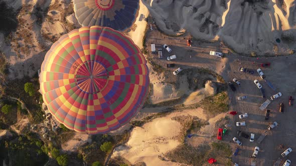 Hot air balloons fly over the mountainous landscape of Cappadocia, Turkey.