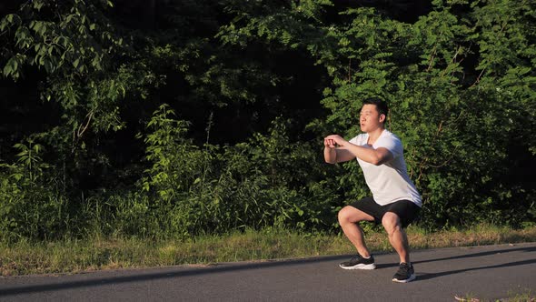 Side View Full Length Shot of Active Fit Young Korean Man Doing Squat Exercise