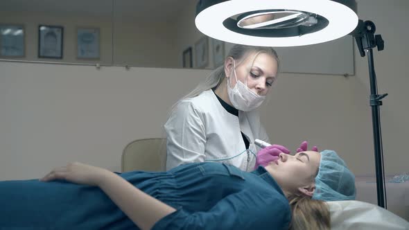 Woman with Long White Hair Applies Permanent Eyebrow Makeup