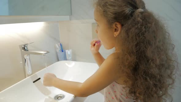 Happy Portrait Cute Caucasian Young Teenage Girl Brushing Teeth in Bathroom. Child Daily Healthcare