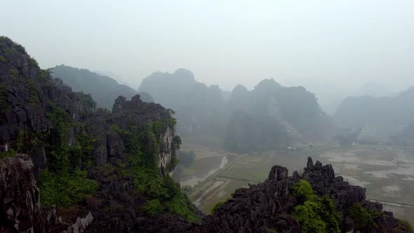 The limestone karst eroded mountains of Tam Coc on Ninh Binh province Vietnam during foggy day, Aeri