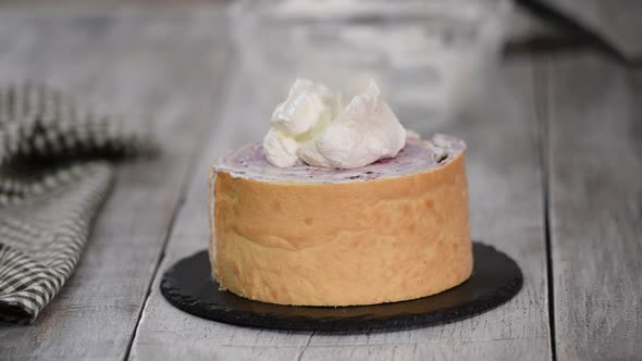 A confectioner prepares a cream cake, Dessert on a white table in the kitchen