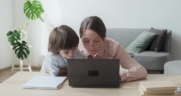 Mom and Son Using the Laptop Together Surfing the Internet Shopping and Playing Games