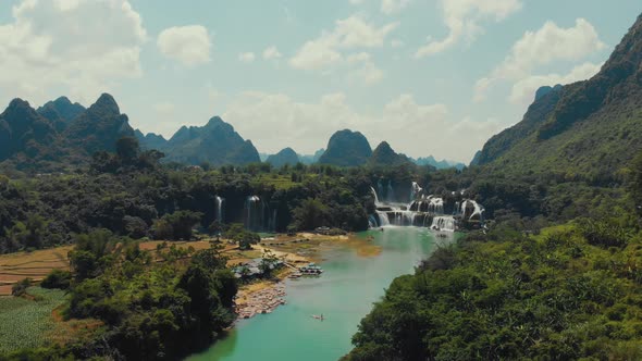 Boats floating near waterfall