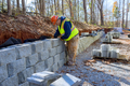 Cement blocks are being used by construction worker to build a retaining wall during development of - PhotoDune Item for Sale