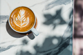 Top view of cup of tasty cappuccino with latte art on marble table background. - PhotoDune Item for Sale