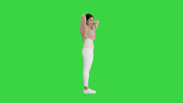 Pretty Woman with Fixing Her Short Brown Hair on a Green Screen, Chroma Key.
