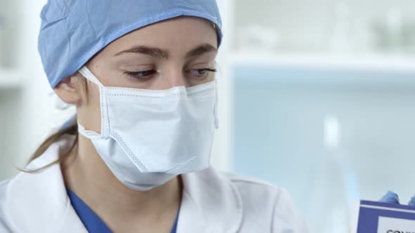 Female nurse wearing face mask holding Covid-19 test kit