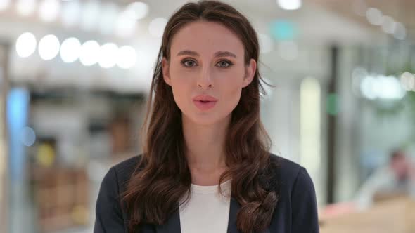 Portrait of Businesswoman with Finger on Lips, Quiet Sign 