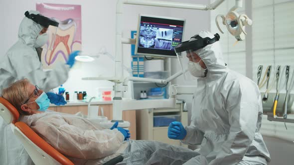 Dentist in Coverall Talking with Woman with Toothache