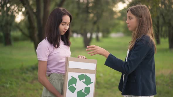 Side View Positive Teenage Ecoactivist Putting Plastic Bottle in Box with Recycling Sign Gesturing