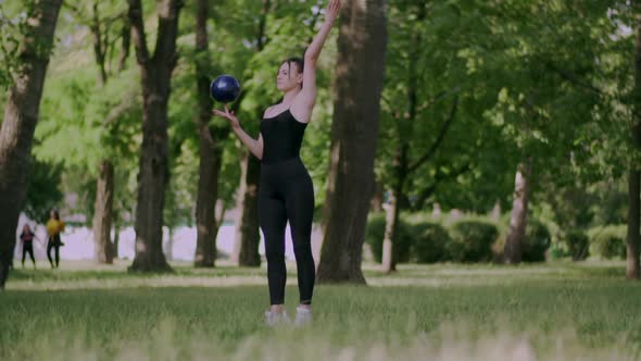 Woman Gymnast Trains with Ball