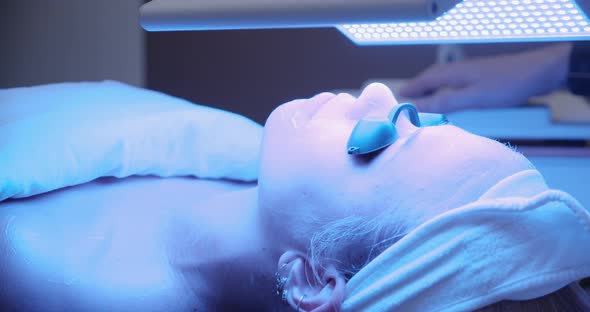 Young Woman In Blue Then Red Sunbed Light