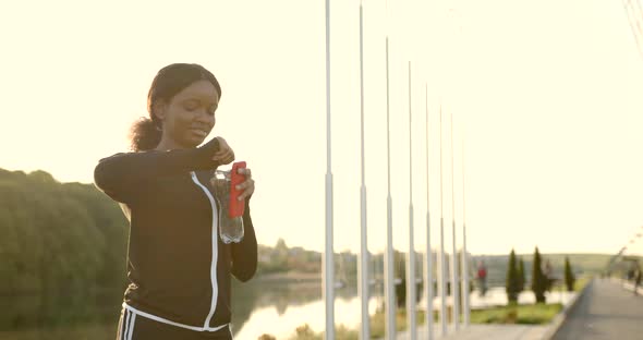 African American Woman Using Smartphone After Training