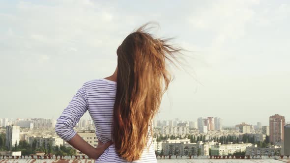 Back View of the Girl and the Panorama of the City