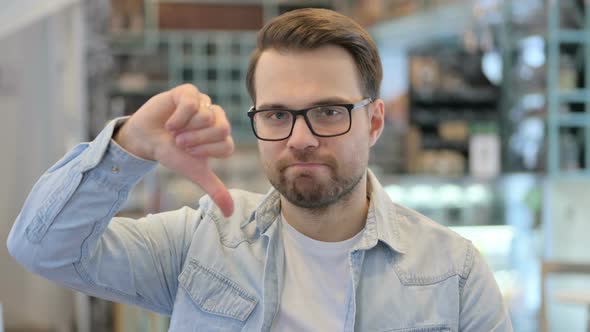 Young Man Showing Thumbs Down Sign