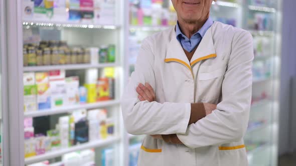 Unrecognizable Senior Male Pharmacist Crossing Hands Smiling Standing in Drugstore