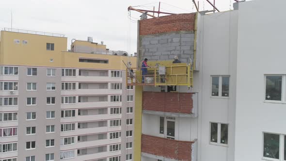 Builders in facade lift Insulation and plastering of multi-storey apartment building 11