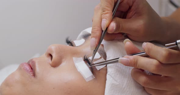 Female woman having eye lash extension in beauty salon