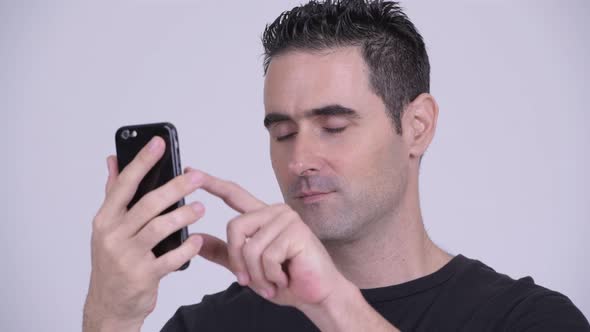 Closeup of Handsome Man Using Phone Against White Background