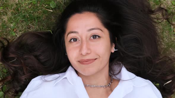 Smiling Woman Lying on Green Grass