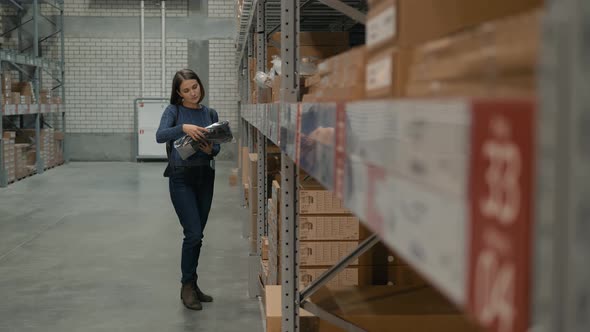 Young Caucasian Woman Choosing Goods in Shop Warehouse