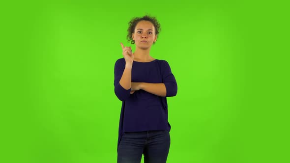 Curly Woman Listening Carefully, Threatening with a Finger and Waves Her Head Negatively. Green