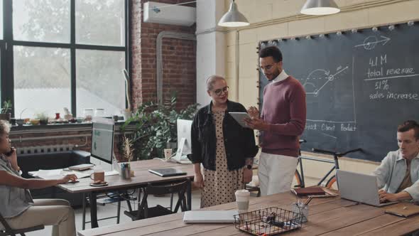 Coworkers Using Tablet Computer on Walk