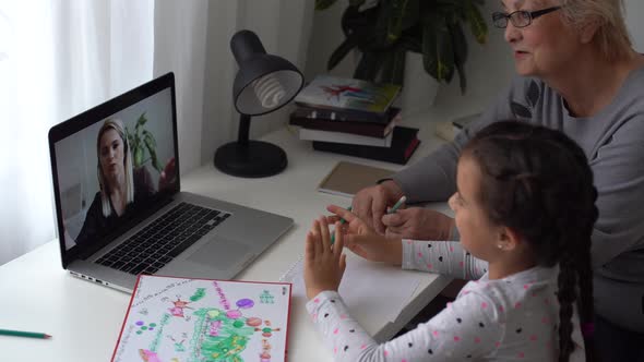 Little Girl Studying with Her Grandmother at Home Use Laptop for Education Online Study Home