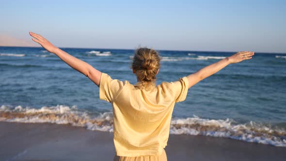 Happy Freedom Woman With Open Arms Looking At Blue Sea.