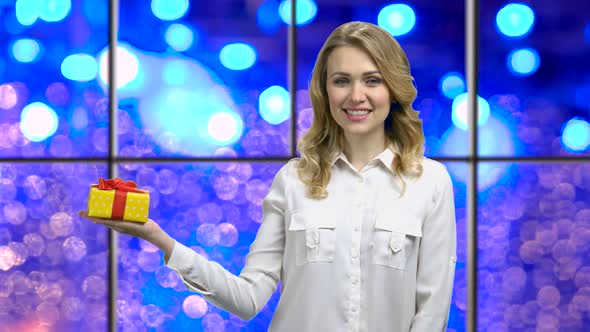 Woman Holding Gift Box on Bokeh Lights Background