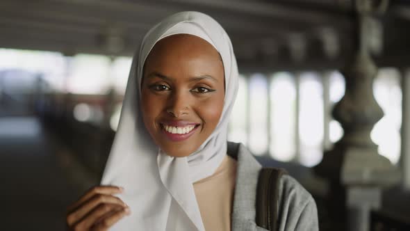 Happy Black Woman Hides Face Behind Hijab Under Bridge