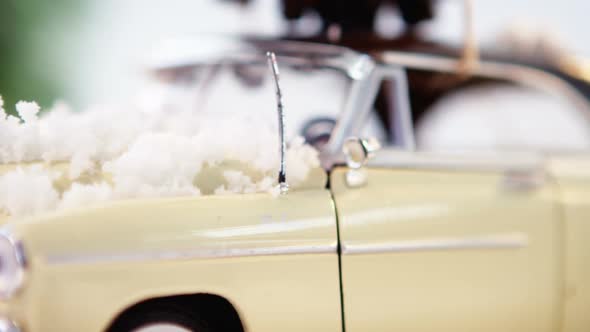 Toy car carrying pine cone with fake snow