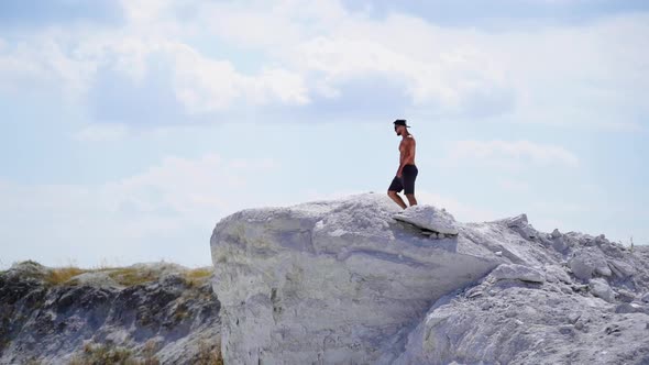 Man on a top of a mountain. Young man standing on cliffs edge of top of the mountain