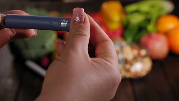Closeup of a Woman with an Insulin Pen on the Background of a Fresh Fruits