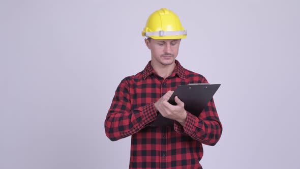 Happy Bearded Man Construction Worker Reading on Clipboard and Directing