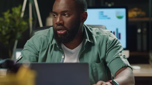 Closeup Disappointed Afro Business Man Talking Via Laptop in Night Office