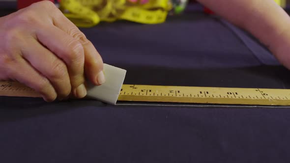 Hands Of Tailor Using Chalk To Mark Fabric 01