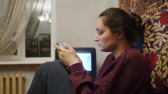 a Sad Girl Watches the Terrible News About the Russian Offensive on the Territory of Ukraine on a