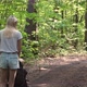 Back view of a mother walking with a stroller in the woods. - VideoHive Item for Sale