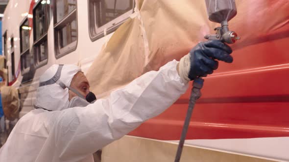 Closeup of the Face of a Male Industrial Painter Who Paints a Wagon the Worker is Wearing a