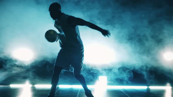 Sportsman is Throwing a Basketball in a Room Filled with Smoke