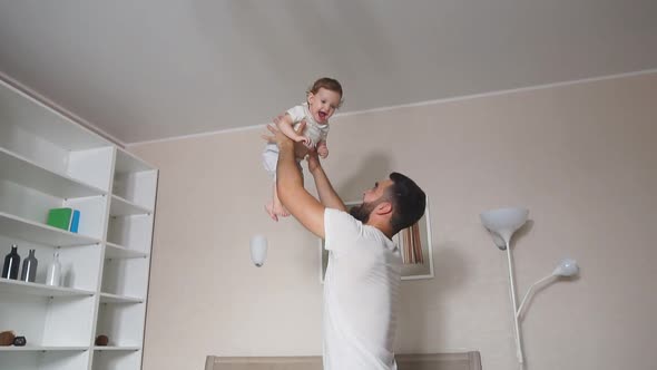 Young Daddy Lifting Daughter Indoors