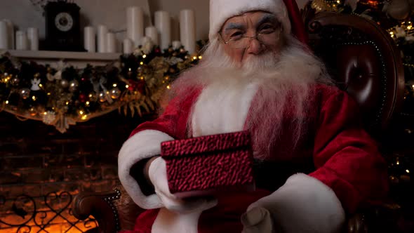 Close Up Smiling Santa Claus Gives Gift in Festive Red Box Christmas Holidays