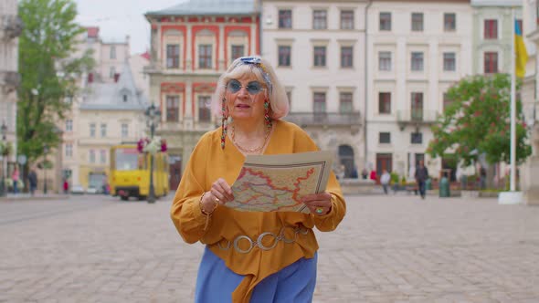 Senior Stylish Tourist Granny Woman Walking Along Street Looking for Way Using Paper Map in City