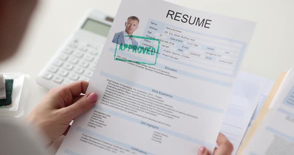 Supervisor Holds Resume of Candidate with Inscription Approved Closeup