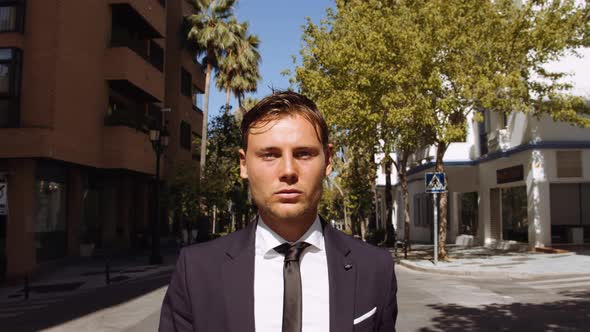 Handsome But Serious Businessman Walking Down Street