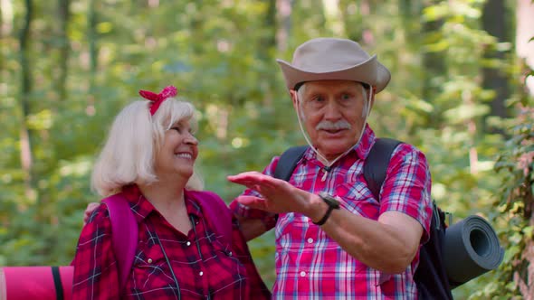 Senior Old Grandmother Grandfather Tourists Enjoying Walking Hiking with Backpacks in Summer Wood